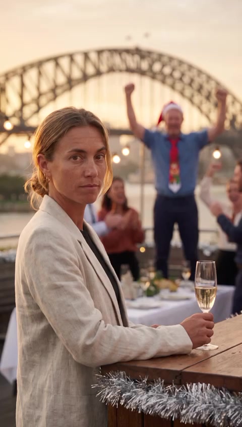Mel watching calmly with a glass of bubbles